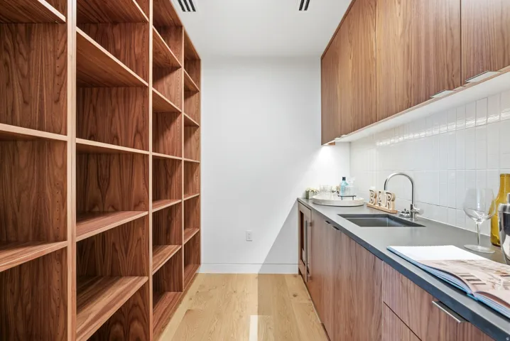 Custom built-in shelving and cabinetry with wood-finish flooring