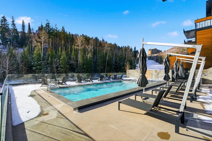 Outdoor heated swimming pool with a surrounding concrete deck