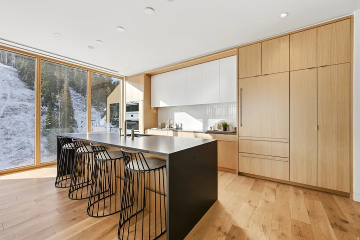 Kitchen with a large island featuring a built-in sink and seating