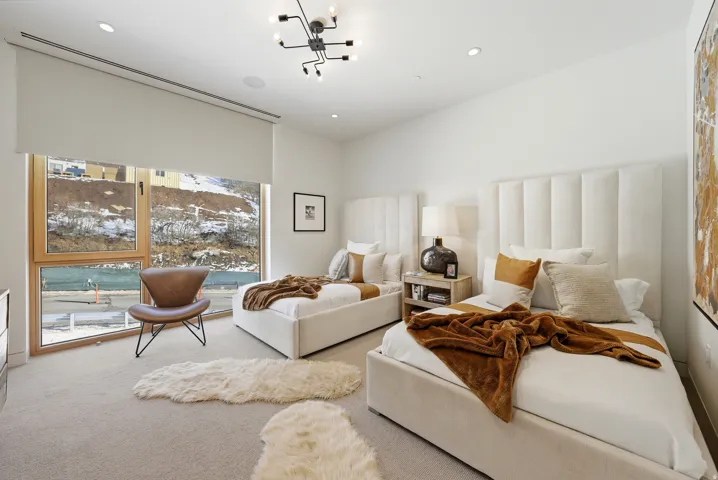 Bedroom featuring a large window with roller shade, recessed lighting, and a modern ceiling fixture