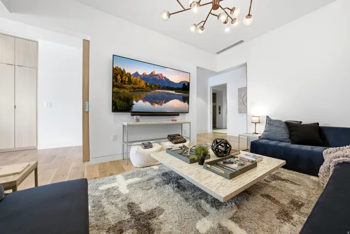 Living area featuring suspended lighting and light wood-style flooring