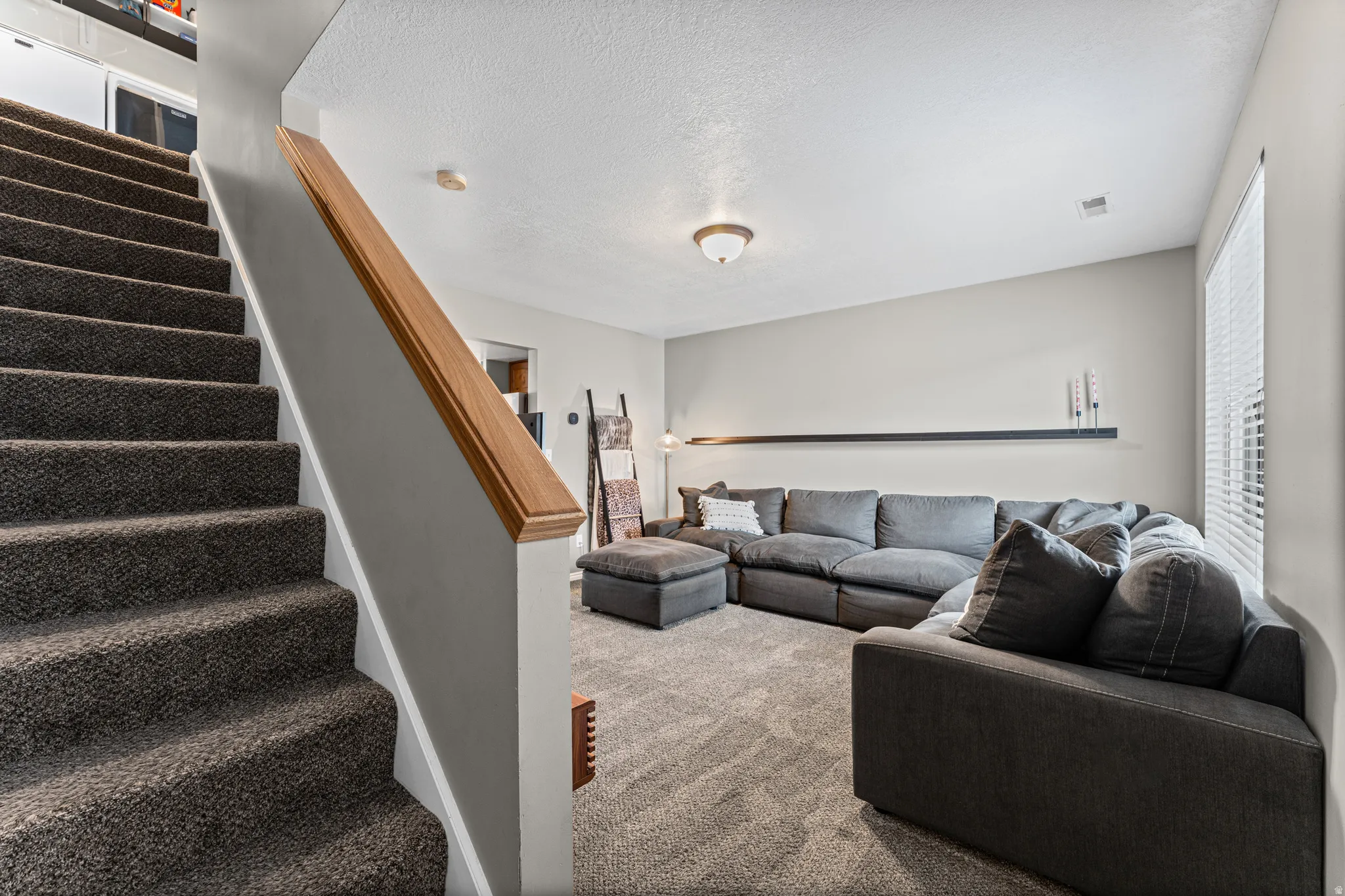 Carpeted stairs with a wood handrail