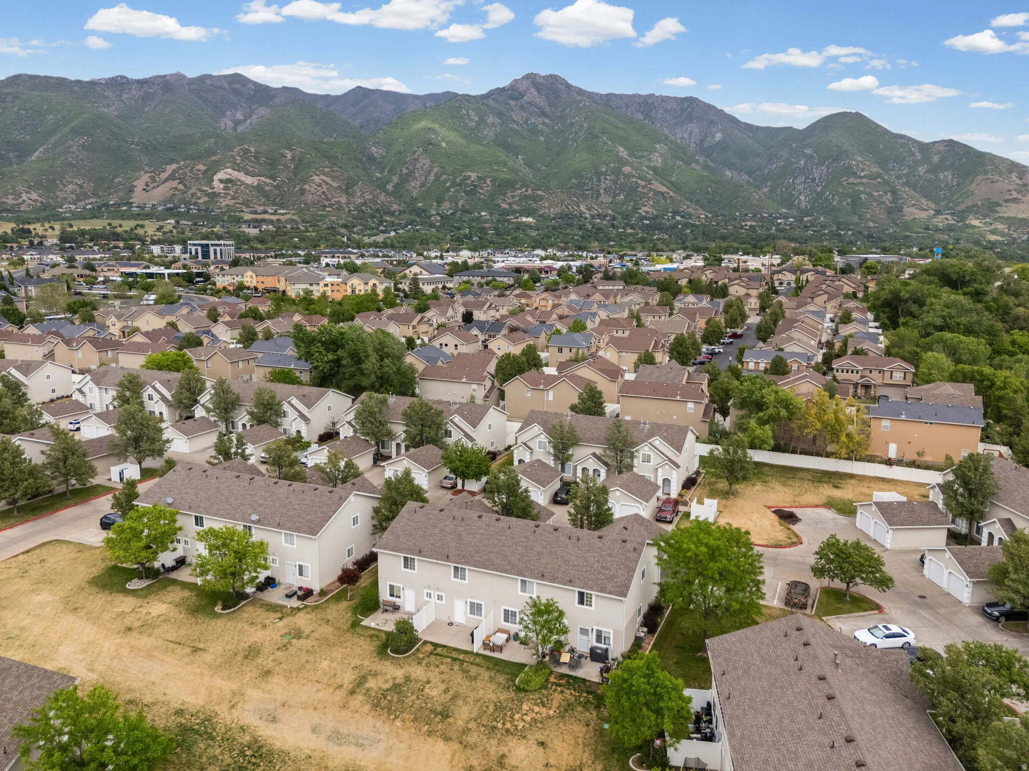 Aerial perspective highlighting a residential community nestled at the base of lush green mountains