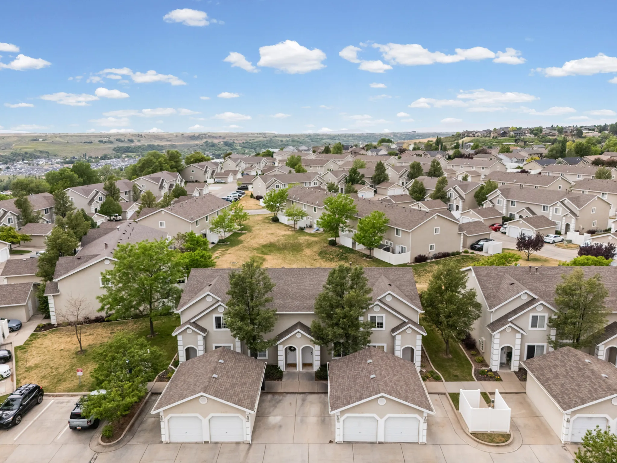 Expansive residential area featuring numerous properties with light-colored siding and dark shingle roofs