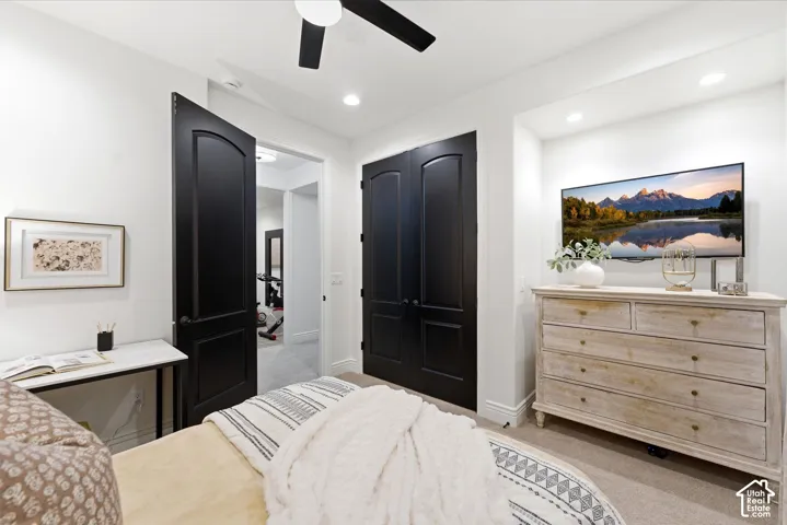 Recessed lighting illuminates this room featuring plush carpeting, a ceiling fan, and two-panel interior doors