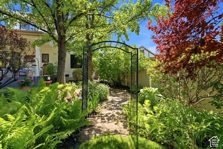 Landscaped pathway featuring a decorative metal archway