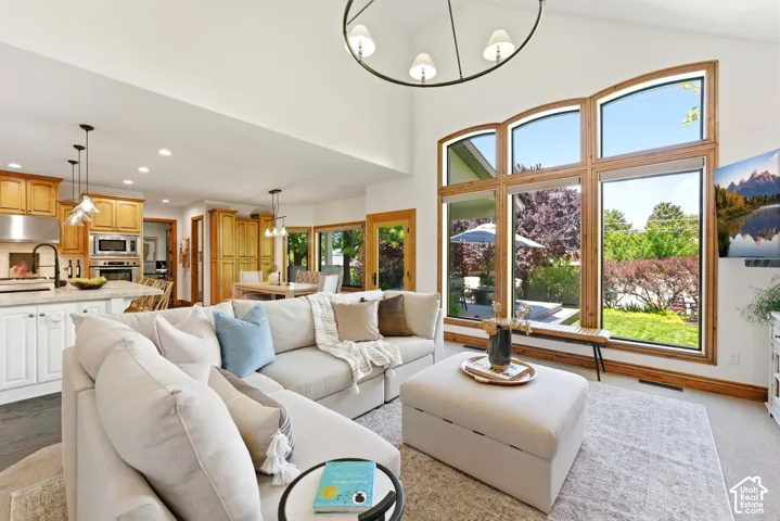 Spacious living area featuring vaulted ceilings and a large multi-pane window with wood-finish framing