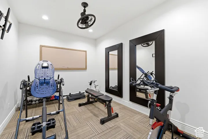 Dedicated exercise room featuring wall-mounted mirrors, recessed lighting, and a ceiling fan