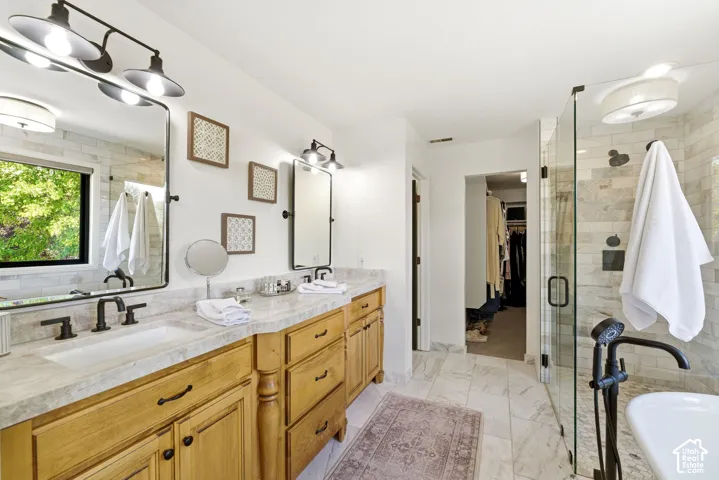 Double vanity with light wood cabinetry and stone countertops