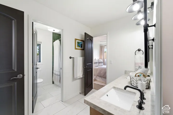 Bathroom vanity featuring a rectangular undermount sink, matte black faucet, and stone-finish countertop