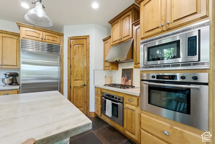 Gourmet kitchen featuring stainless steel appliances, custom cabinetry, a built-in oven, microwave, and a gas cooktop