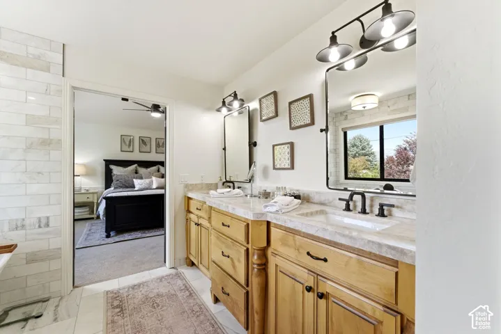 Dual vanity with wood cabinetry and light stone countertops