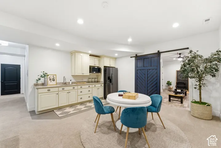 Kitchenette featuring cream cabinetry, stainless steel appliances, and a light-colored countertop