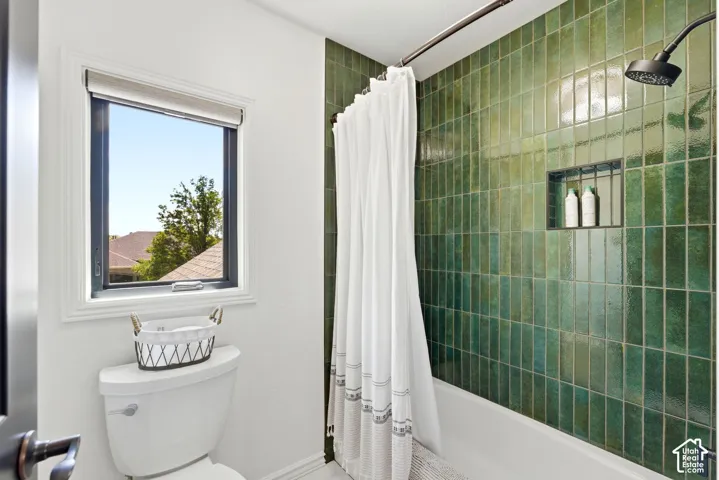 Bathroom featuring a bathtub with subway tile surround, recessed shower niche, and a dark bronze shower fixture