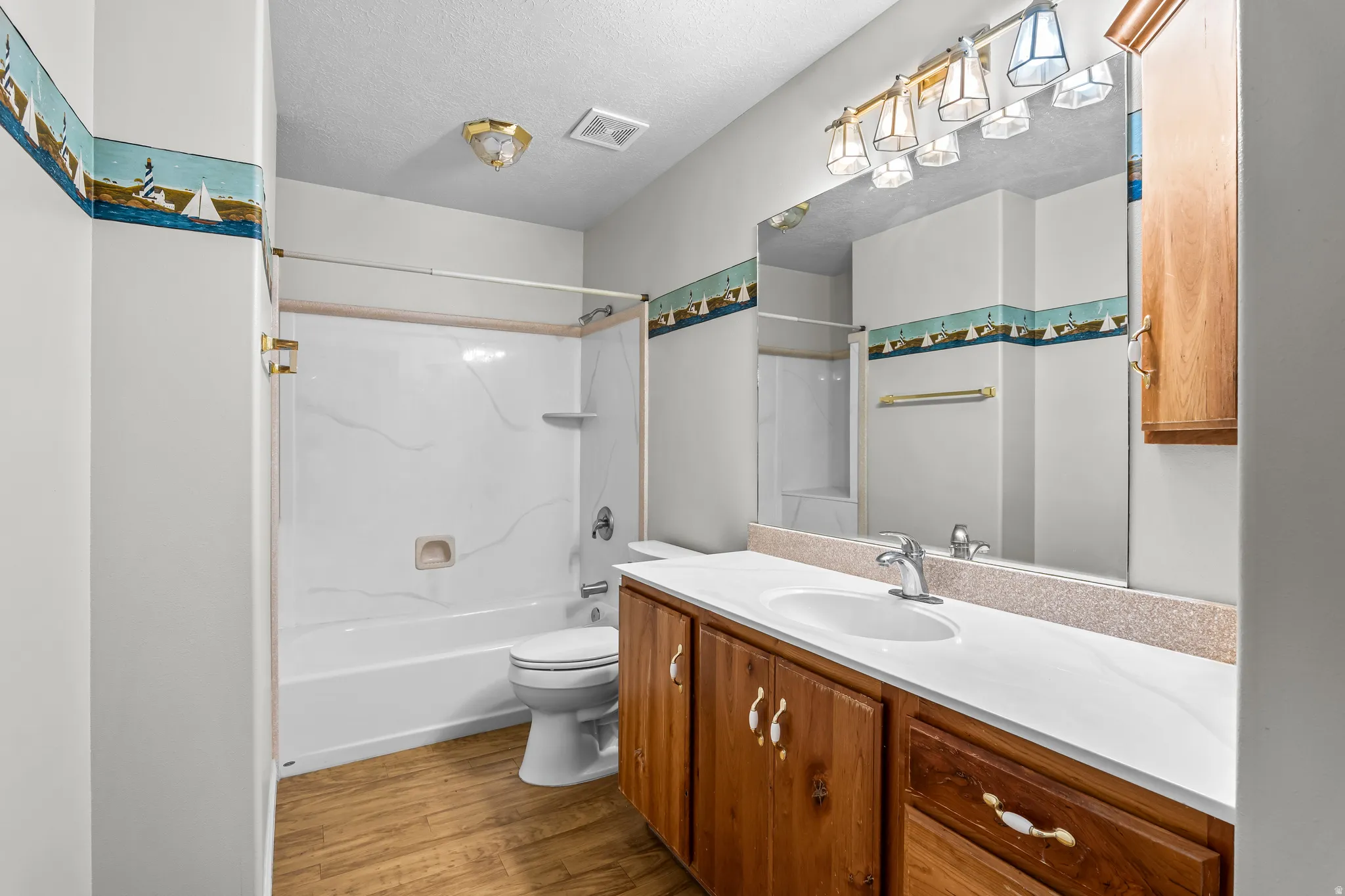 Full bathroom featuring a single vanity with wood cabinetry and a white countertop