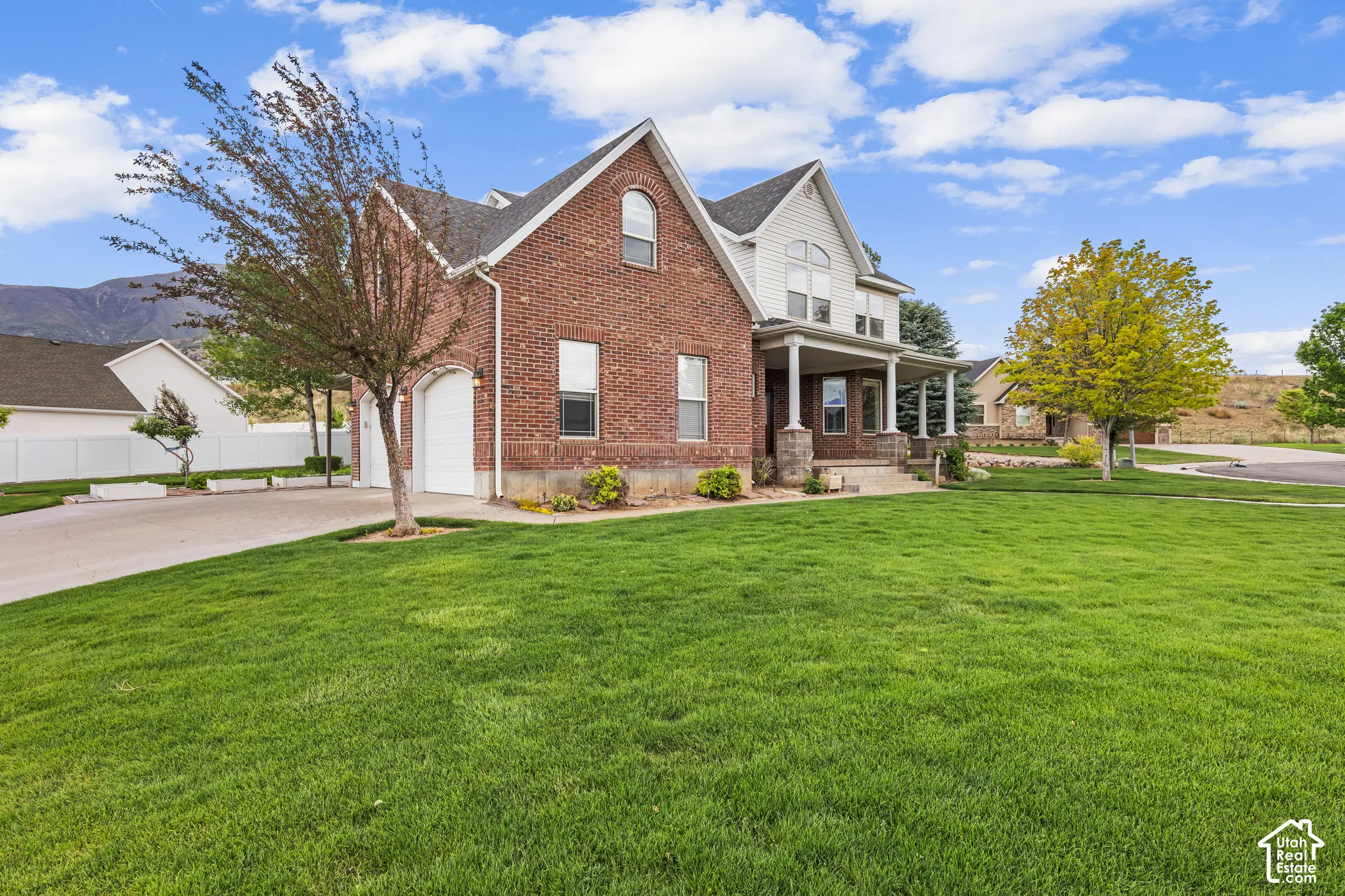 Brick and siding exterior featuring a covered front porch with stone pillars