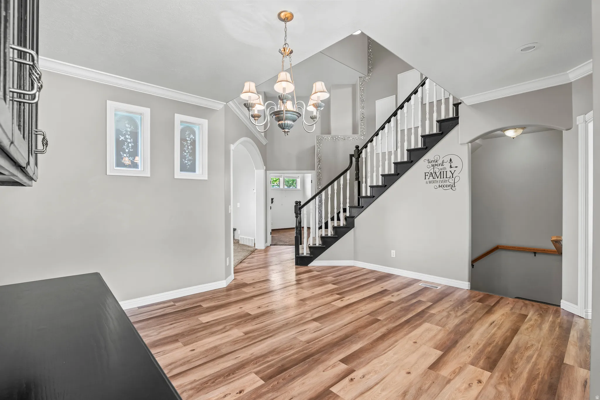 Entryway featuring a grand staircase with dark treads and white balusters