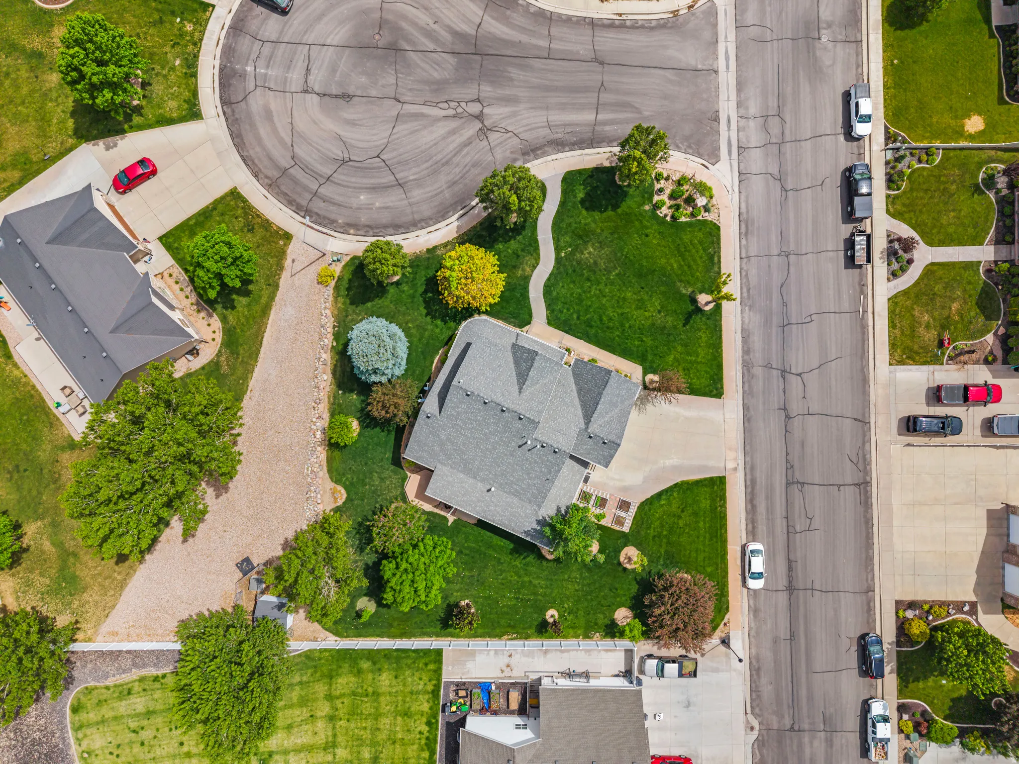 Aerial perspective showcasing a residential property with a multi-gabled roof and a well-maintained lawn