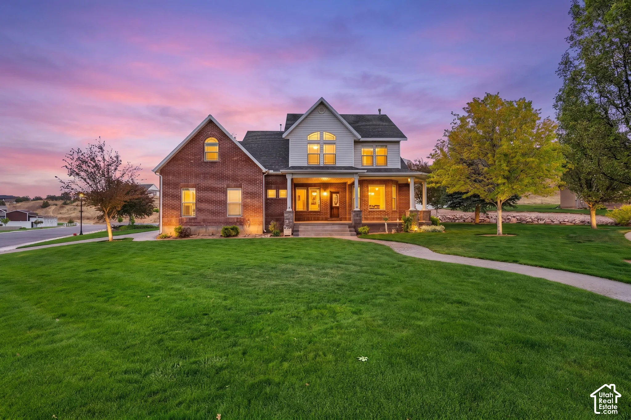 Two-story residence featuring a brick and siding exterior, a covered porch with white columns, and multiple gabled rooflines
