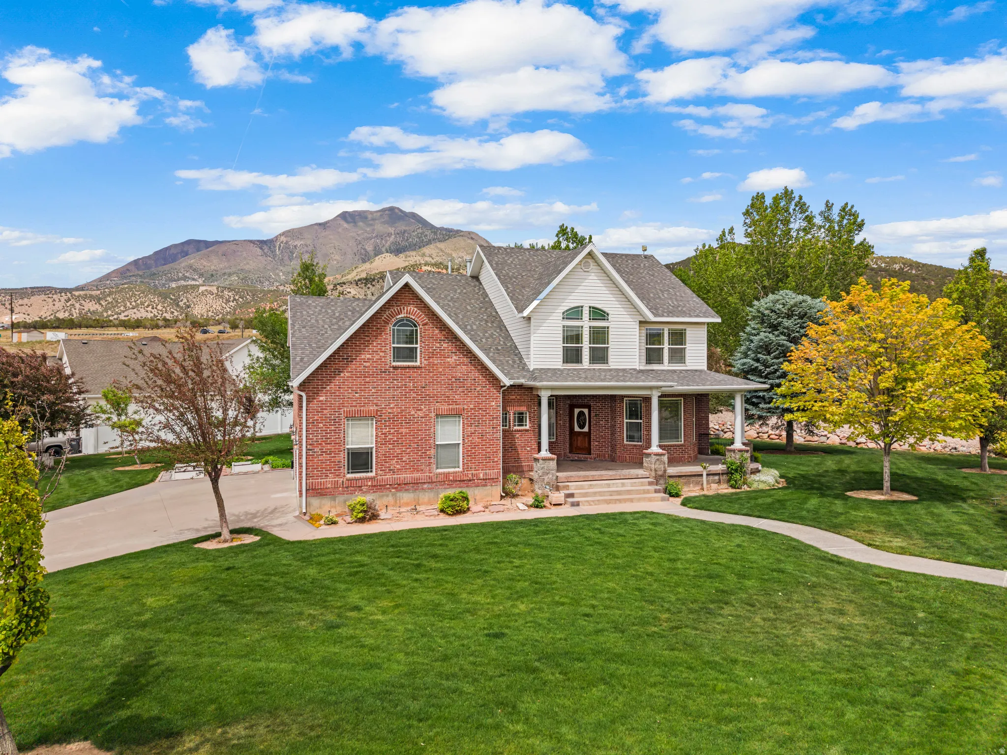 Traditional two-story residence featuring a brick facade and white siding