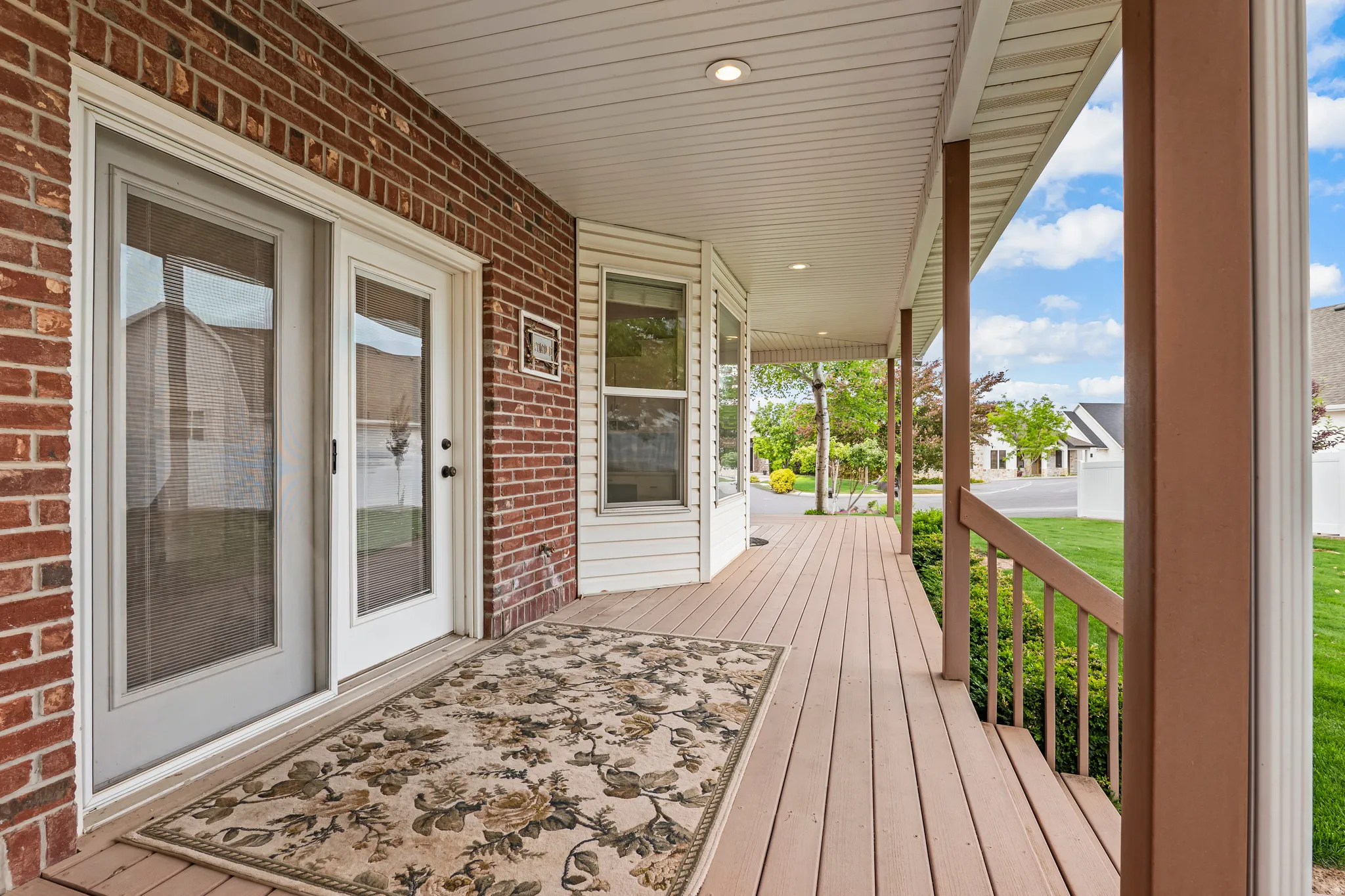 Expansive covered porch featuring wood-finish decking and white vinyl soffit