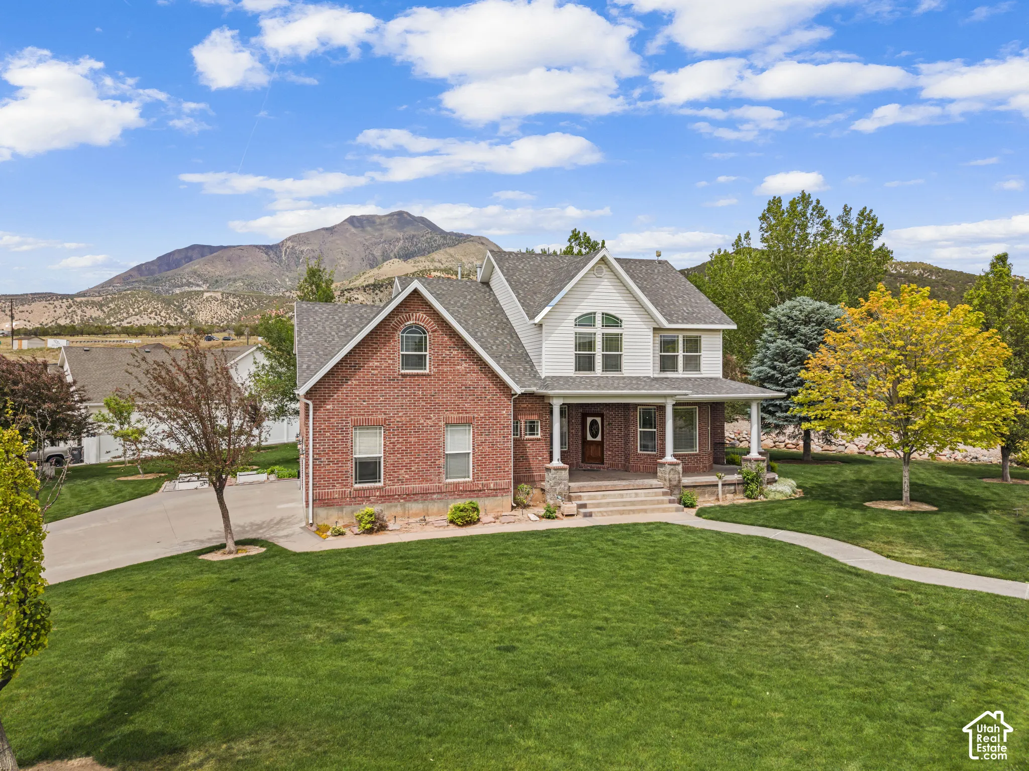 Traditional two-story residence featuring a brick facade and white siding