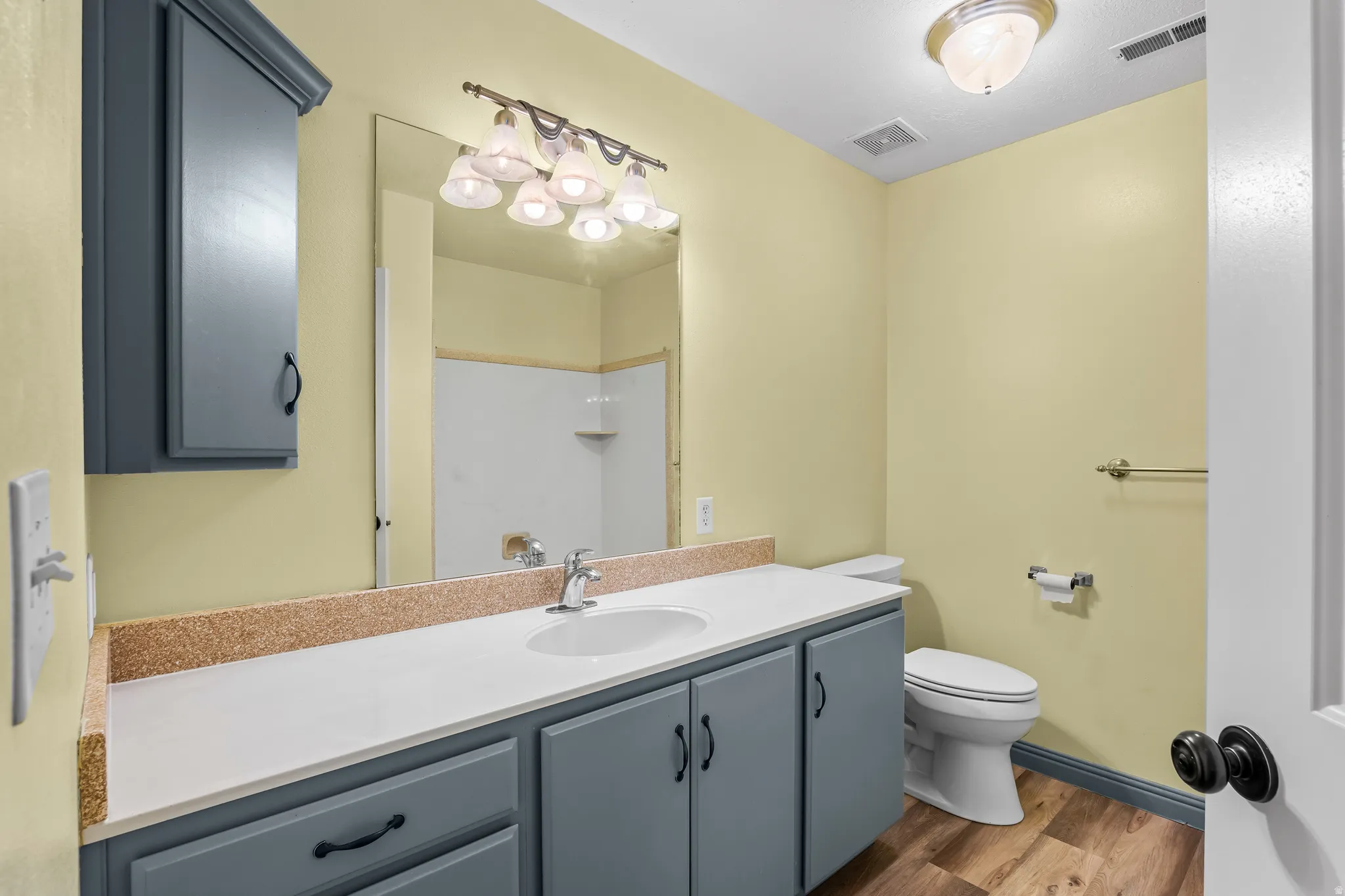 Bathroom vanity featuring light-toned cabinetry, a white countertop, and a single basin sink