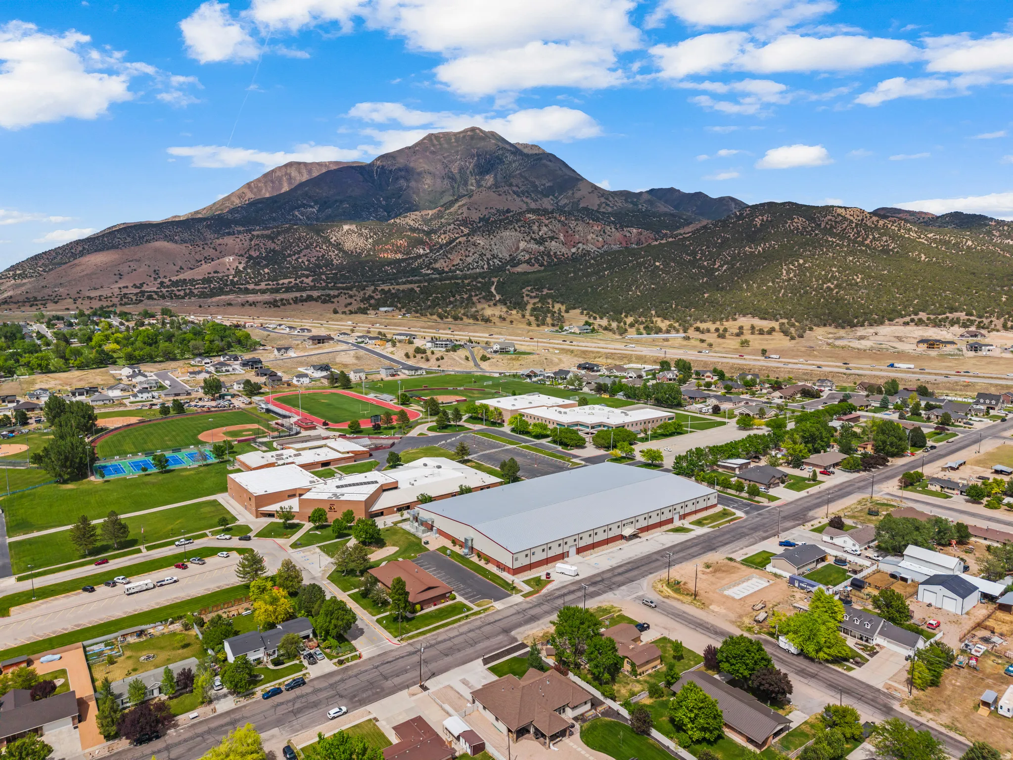 Expansive mountain backdrop with a residential area featuring established homes and green spaces