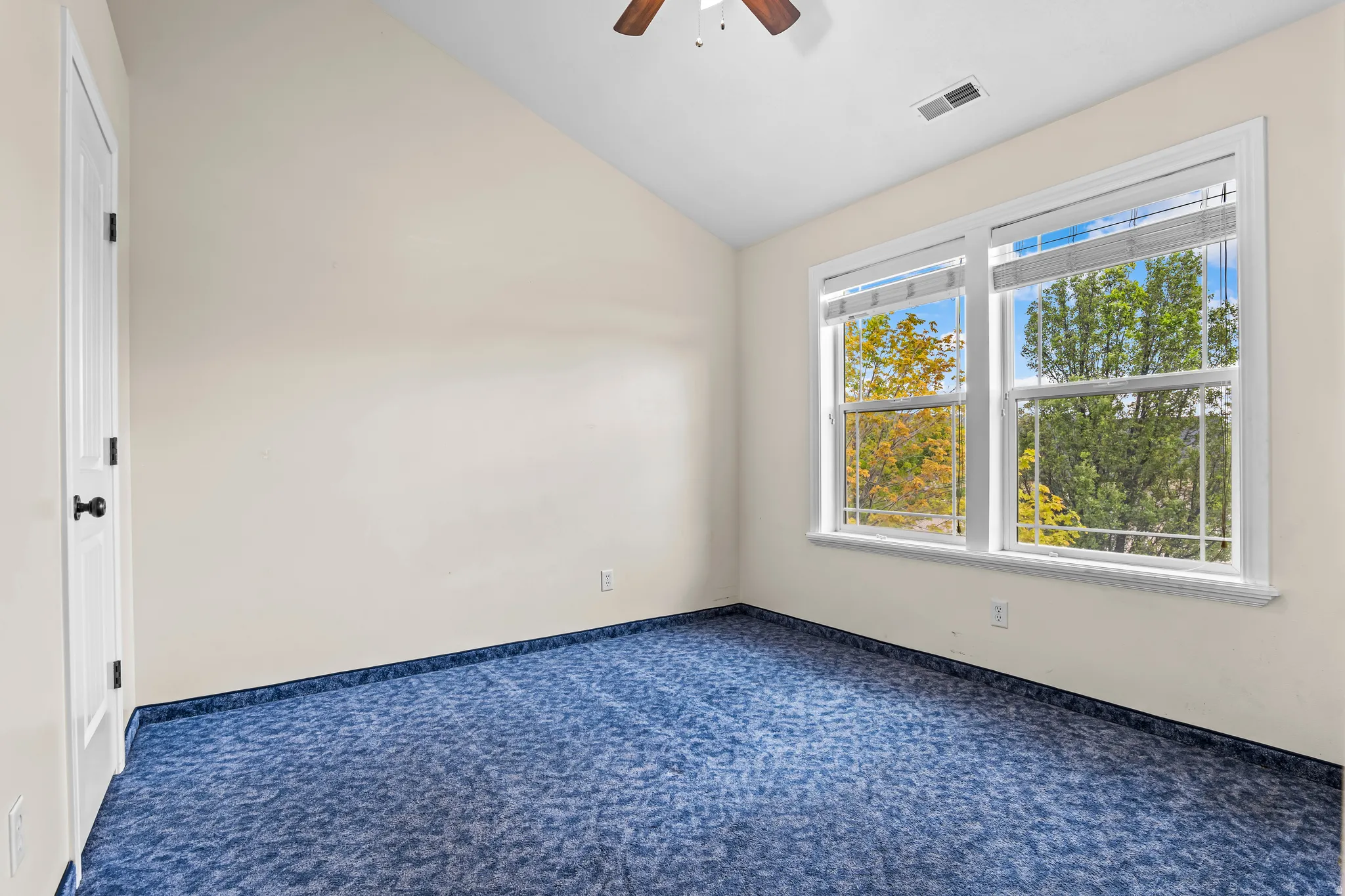 Room featuring a vaulted ceiling and dual pane windows