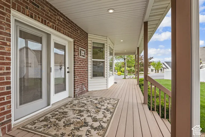 Expansive covered porch featuring wood-finish decking and white vinyl soffit