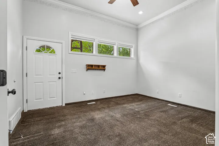 White paneled entry door with an arched glass insert, accompanied by a transom window array
