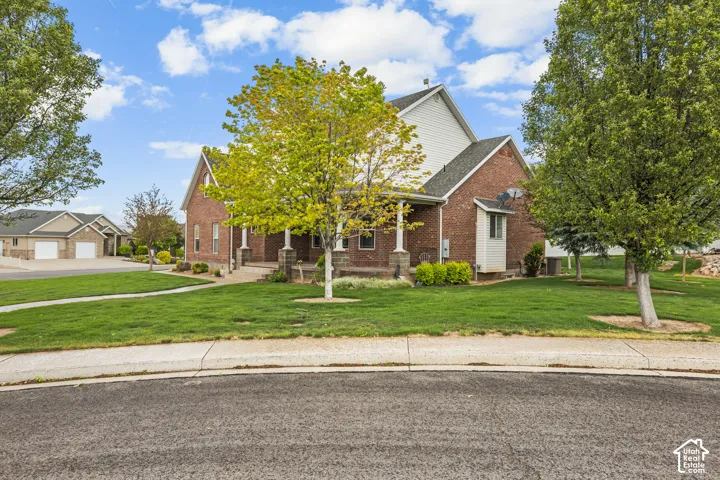 Traditional brick home with white siding accents and a covered front porch featuring column supports