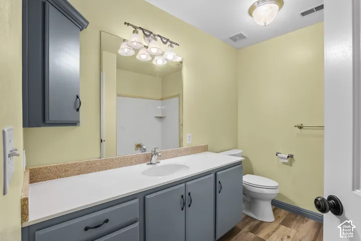 Bathroom vanity featuring light-toned cabinetry, a white countertop, and a single basin sink