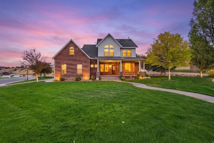 Two-story residence featuring a brick and siding exterior, a covered porch with white columns, and multiple gabled rooflines