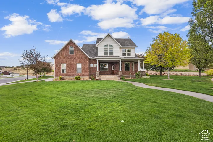 Brick and siding exterior featuring a covered front porch with white columns