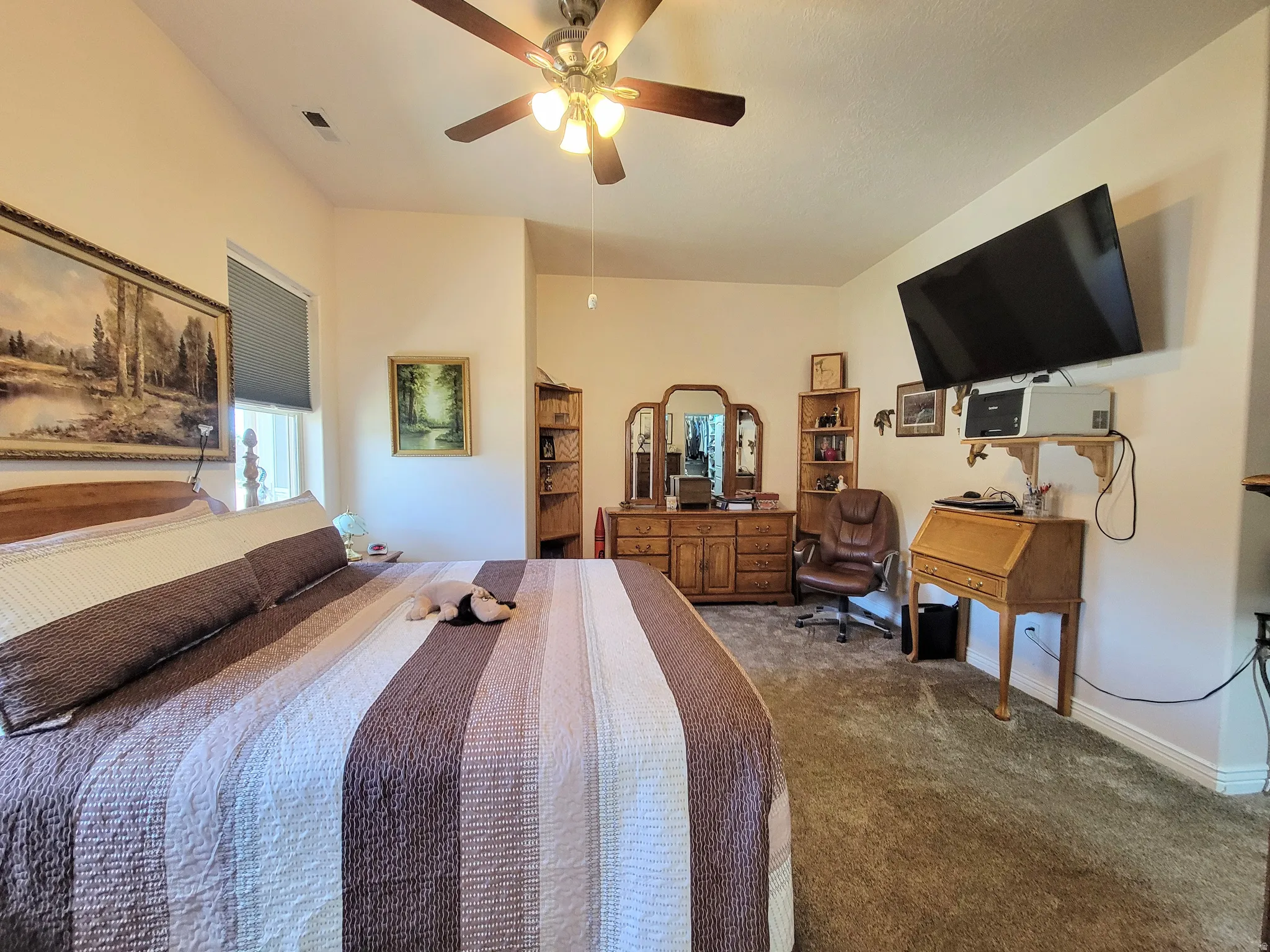 Spacious room featuring vaulted ceilings, a ceiling fan with light fixture, and a window with blinds