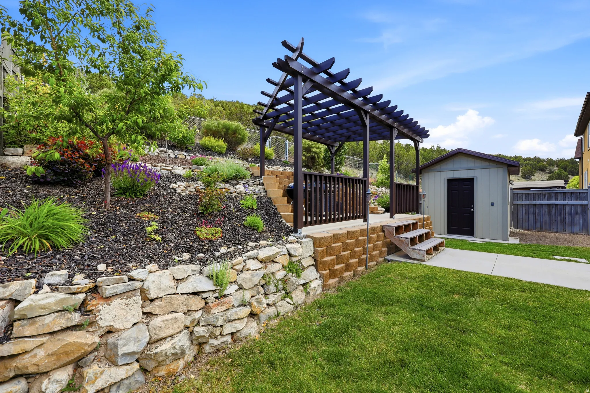 Terraced landscaping with a stone retaining wall and varied plantings