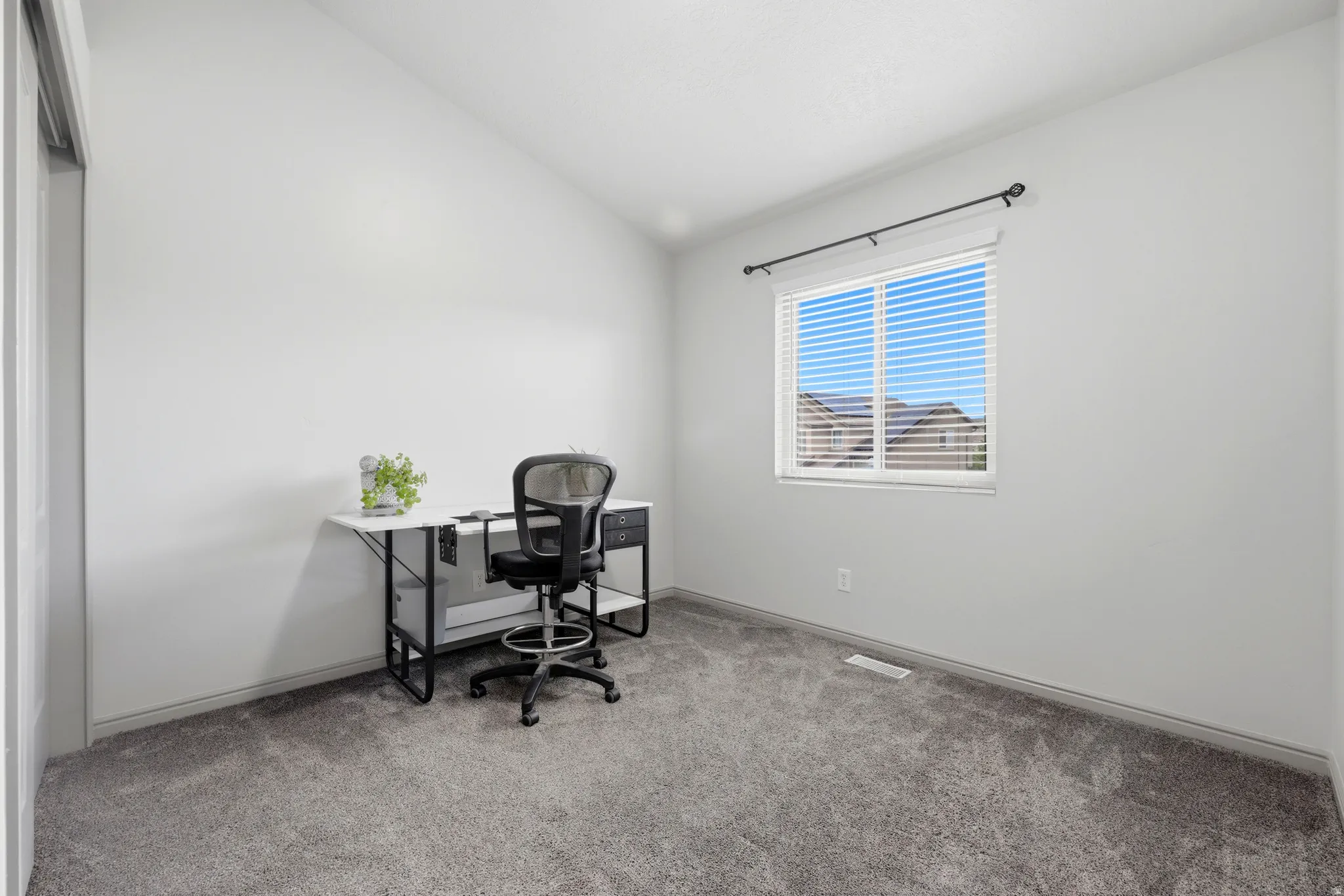 Room featuring a vaulted ceiling, neutral wall paint, and grey carpeting
