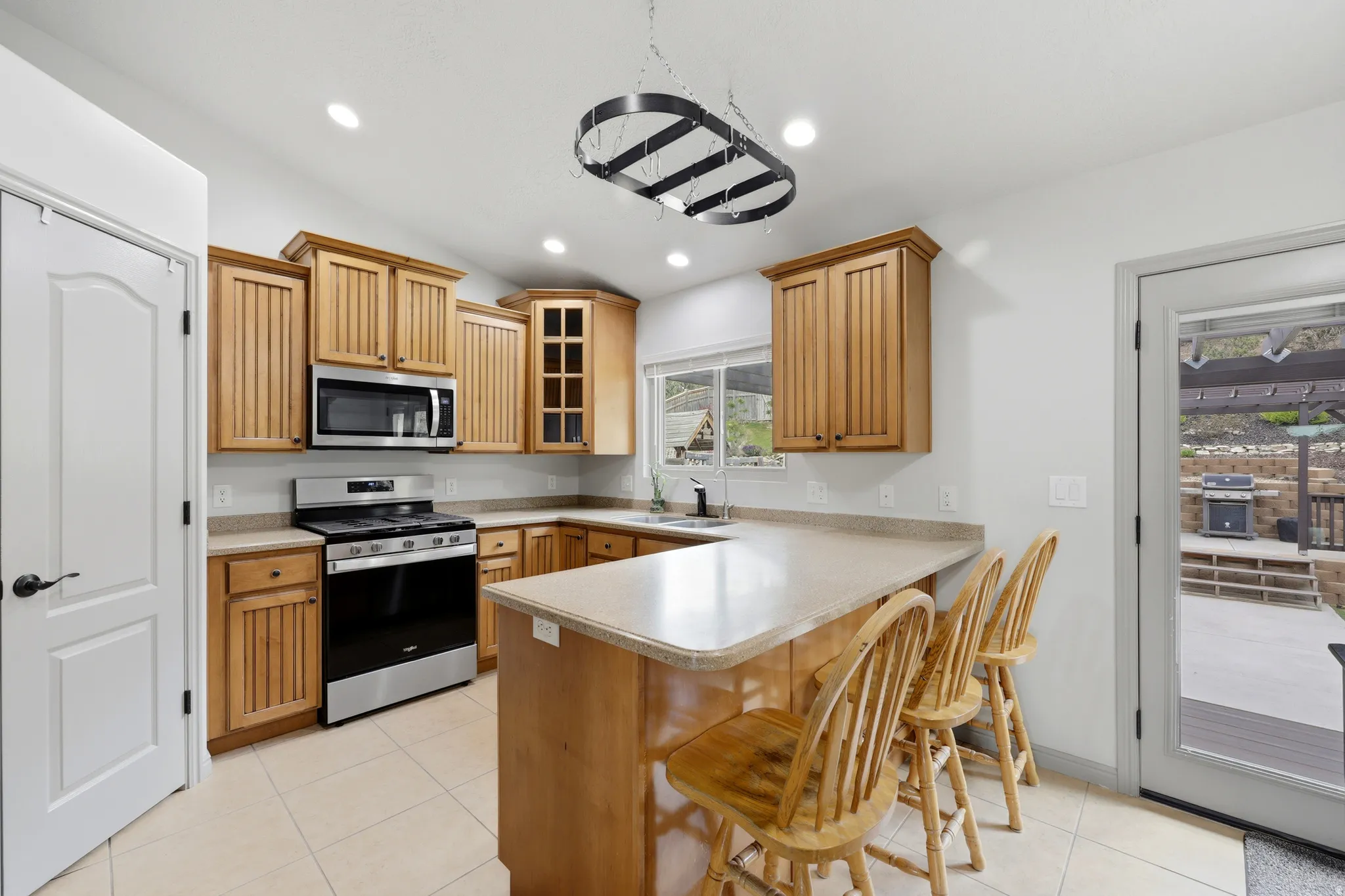 U-shaped kitchen featuring wood-finish cabinetry, stainless steel appliances, and a central island with a breakfast bar