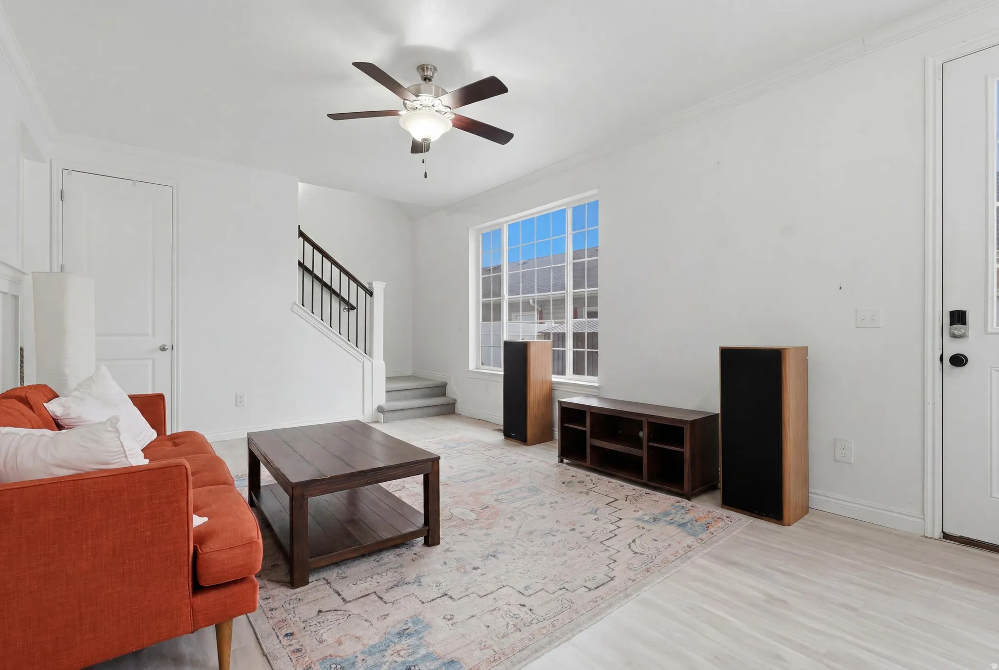 Light wood-finish flooring complemented by a ceiling fan with integrated lighting