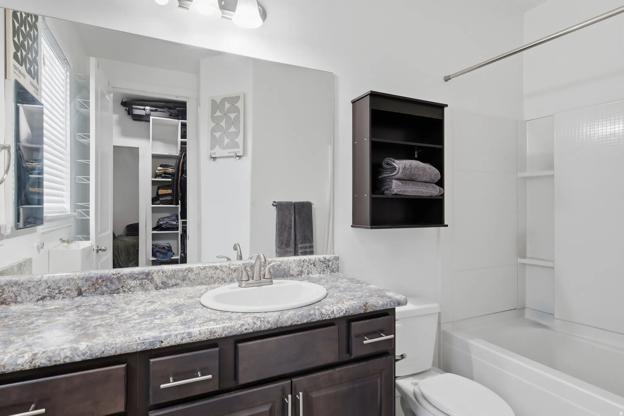 Bathroom vanity with a white oval sink, brushed nickel faucet, and a patterned countertop