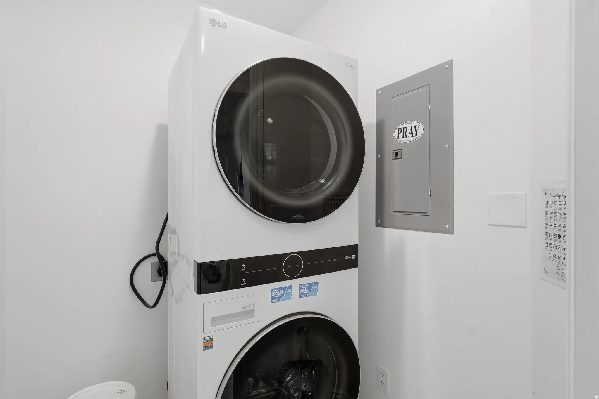 Stacked washer and dryer unit, featuring a white finish and front-loading design