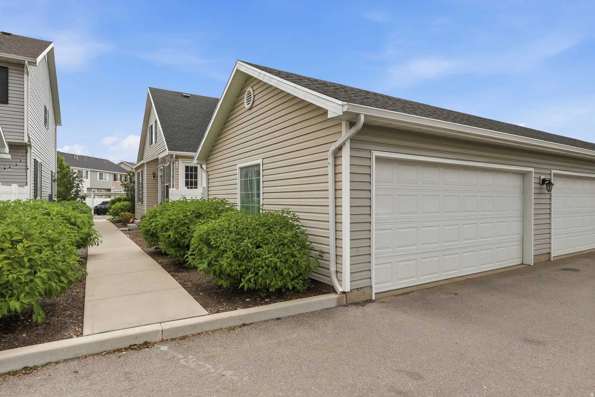 Attached two-car garage with panel doors and exterior lighting