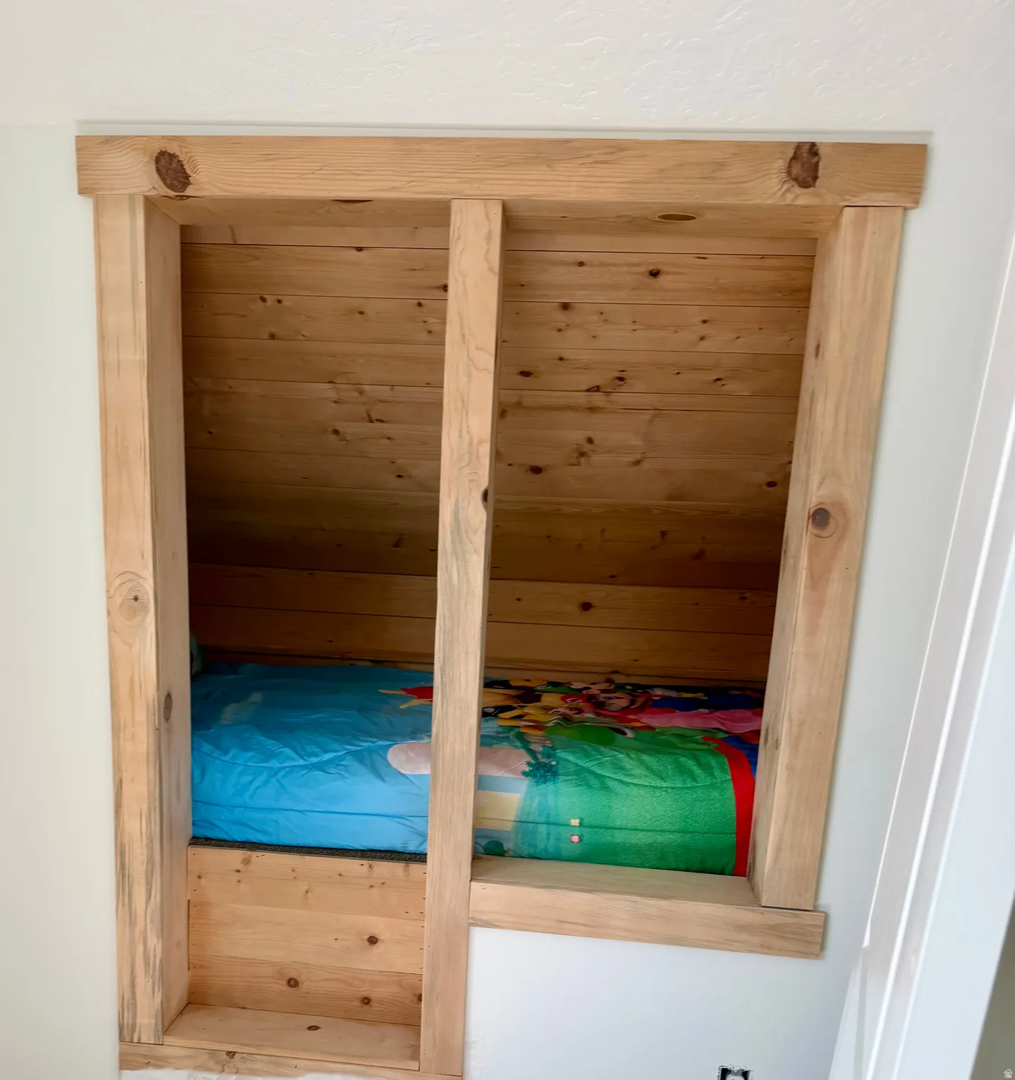 Custom built-in nook with natural wood paneling and a light wood-finish frame