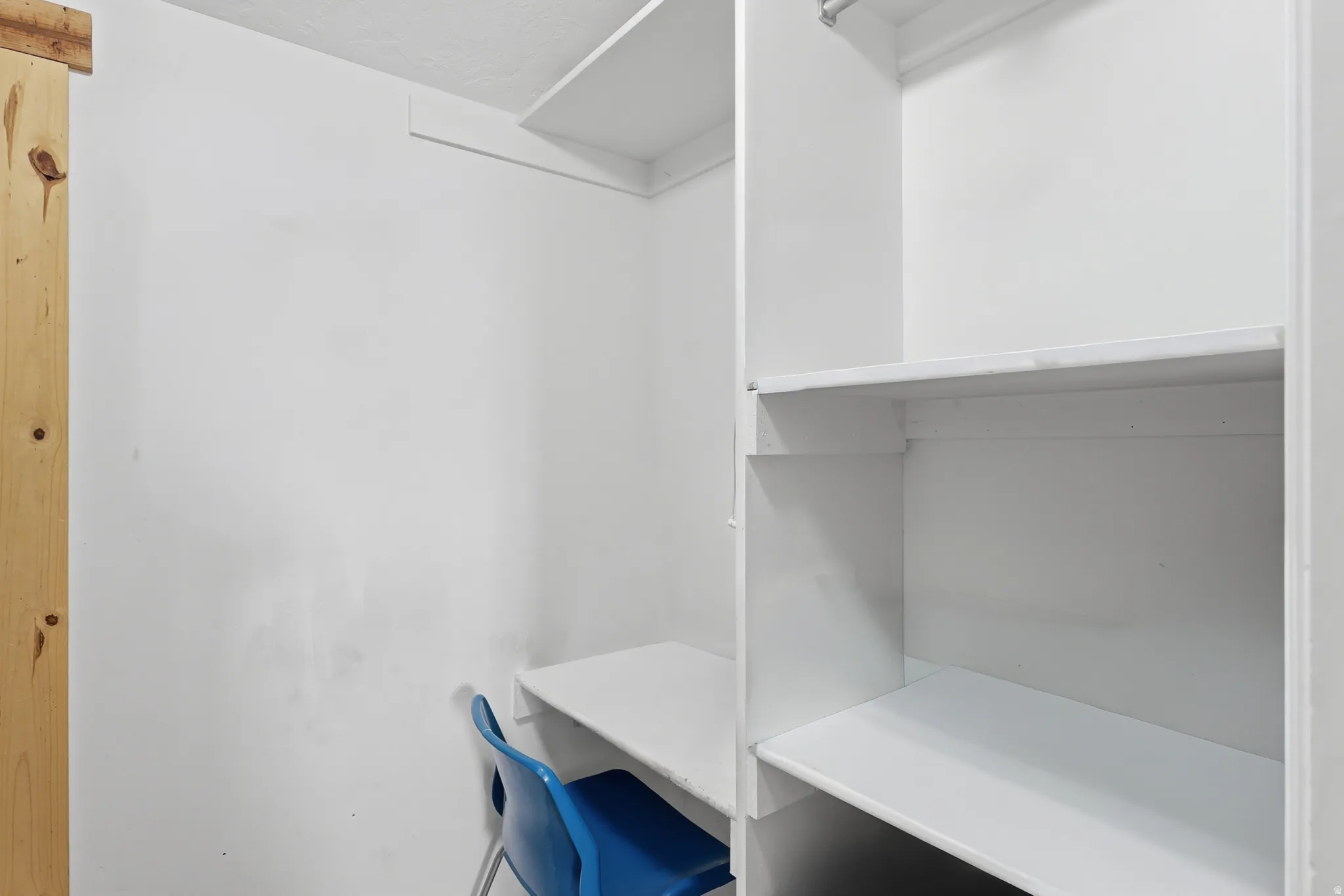 Custom closet system featuring white shelving and a built-in desk area