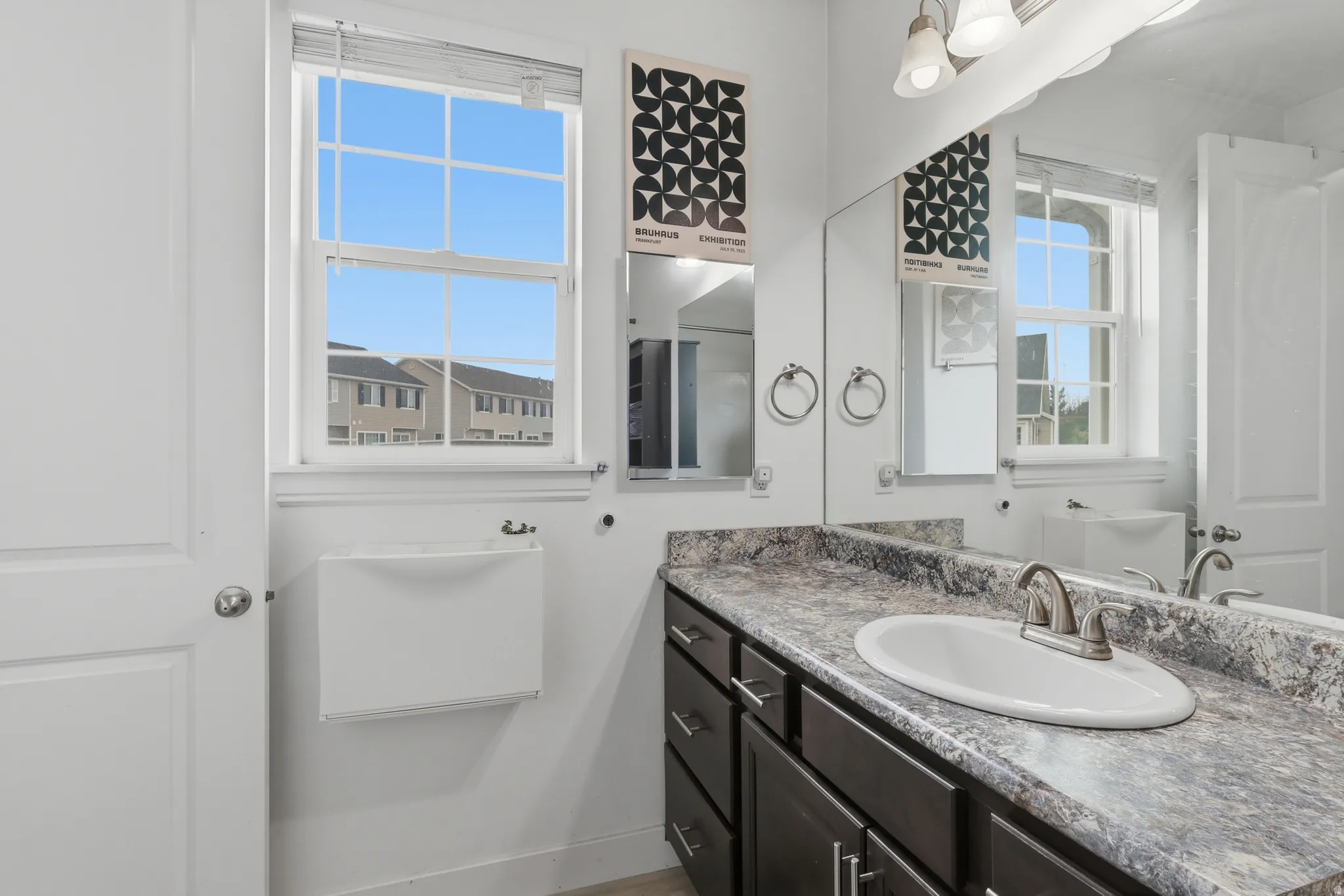 Bathroom vanity featuring a built-in oval sink, brushed nickel faucet, and a patterned countertop
