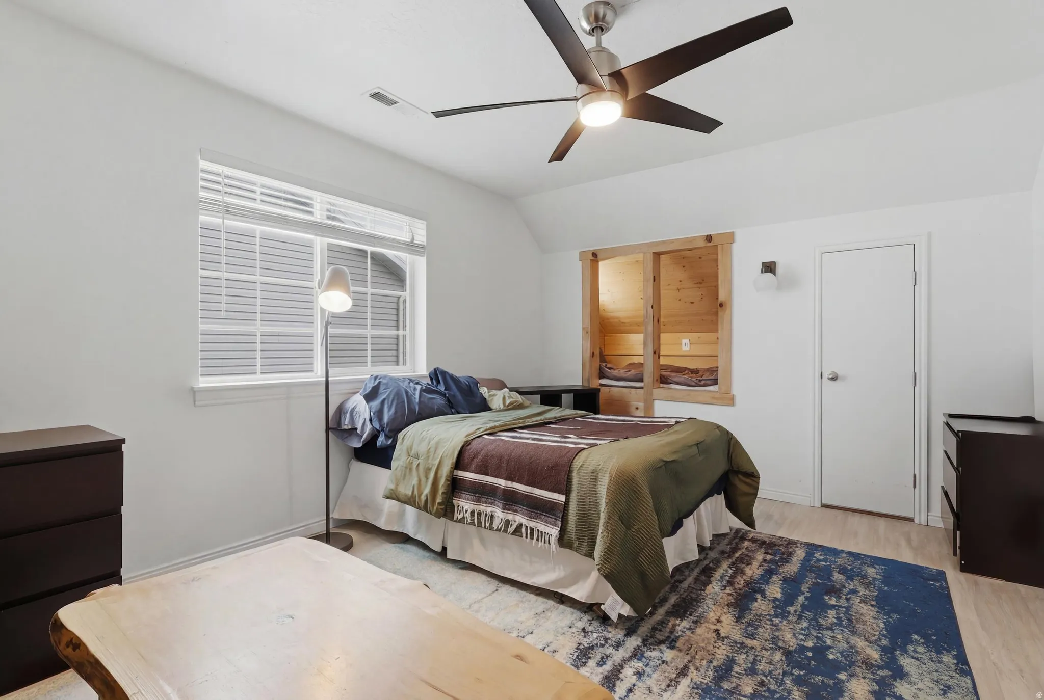 Spacious interior featuring light wood-finish flooring, white walls, and a contemporary ceiling fan