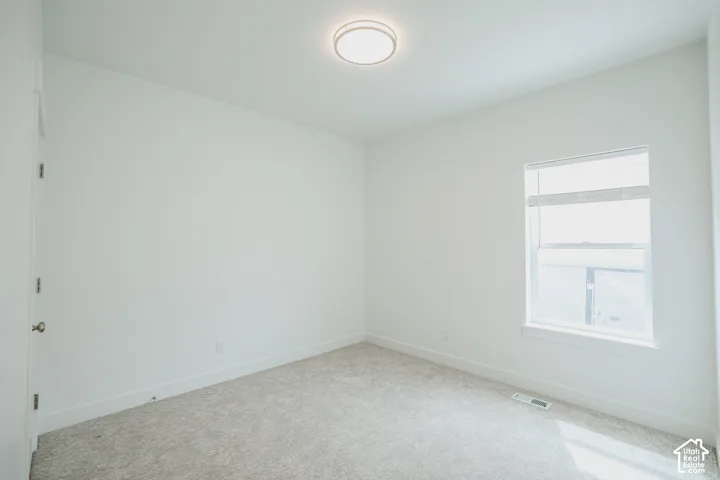 Neutral carpeting with white baseboards and light-colored walls