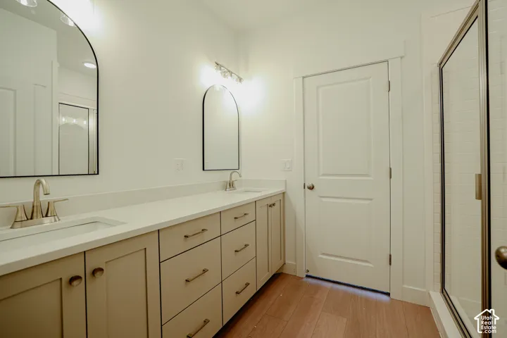 Double vanity with neutral cabinetry, light-toned countertops, and brushed nickel hardware