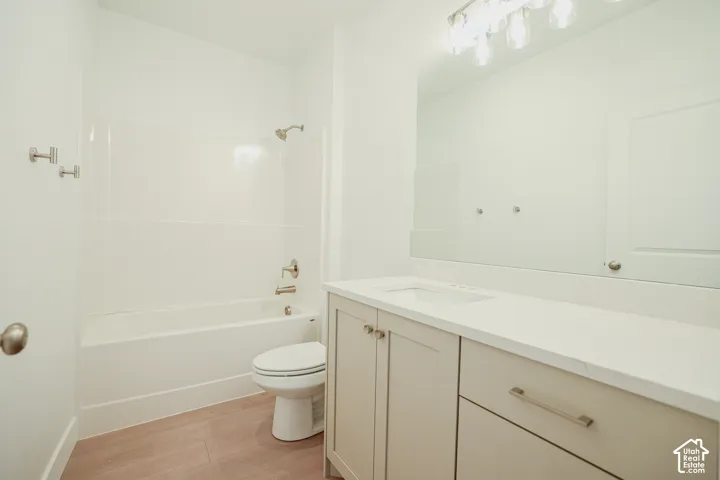 Contemporary bathroom featuring a light-toned vanity with an integrated sink, polished hardware, and a coordinating countertop